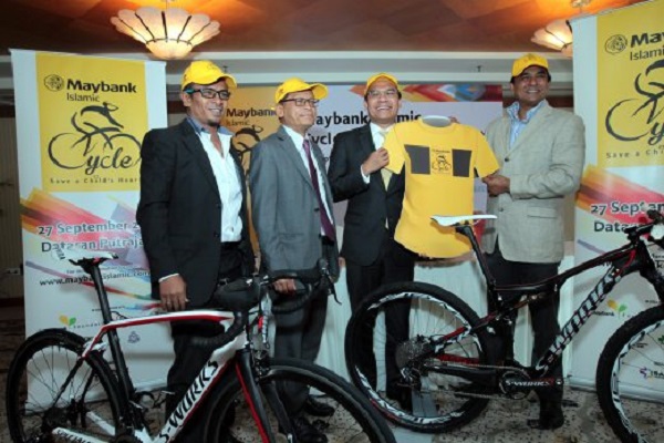 KUALA LUMPUR 19 SEPTEMBER 2014. M.Kumaresan (right) and CEO Maybank Iaslamic Berhad Muzaffar Hisham (second right) holds the event T'Shirt looks on EX Cycelist Musairi Musa (left) and CEO Institut Jantung Negara Datuk Dr.Mohd Azhari Yakub (second left) at Maybank Islamic Cycle "Save a Child's Heart media conference.NSTP/ S.Sugumaran